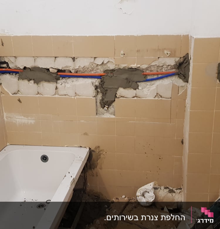 צינורות מים בקיר חדר אמבטיה בתיקון